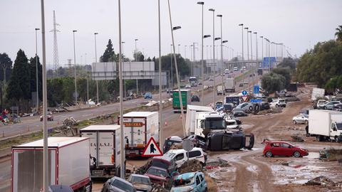 Spanien, Valencia: Autos liegen nach den Überschwemmungen auf der Seite einer Hauptstraße. Fo