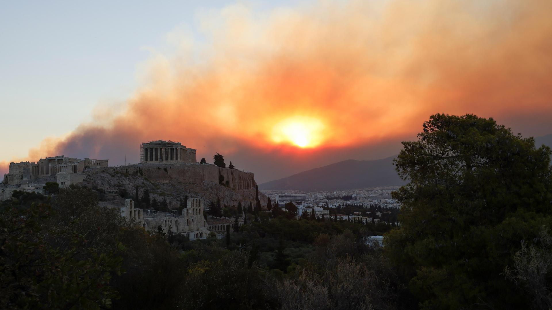 Rauch steigt über dem Parthenon-Tempel während eines Waldbrands in Athen auf. Rauch steigt über dem Parthenon-Tempel während eines Waldbrands in Athen auf.