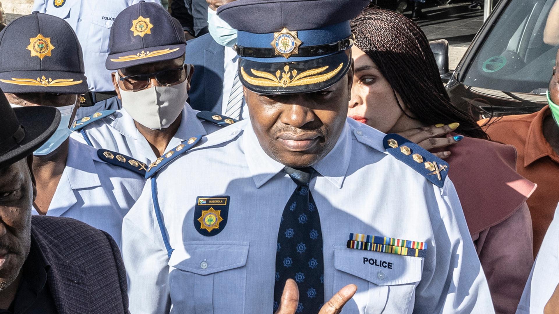 Südafrikas Polizeichef Masemola steht in Uniform in einer Menschenmange.