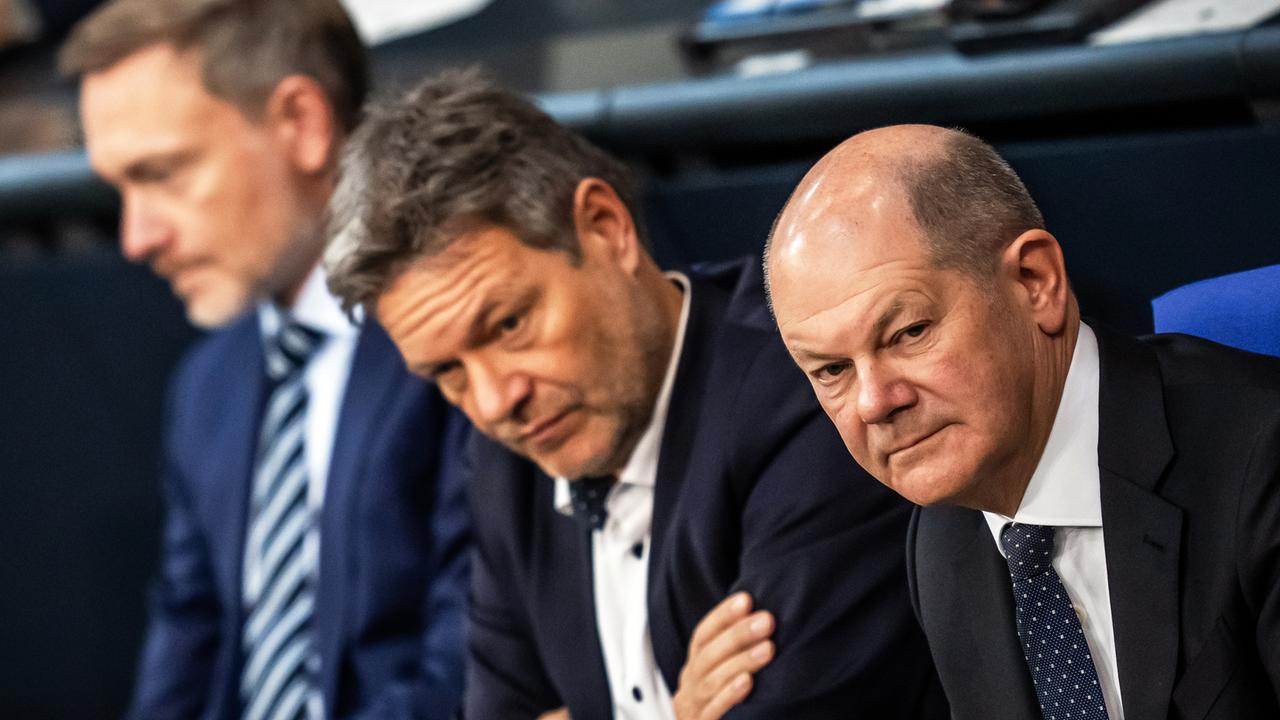 Bundeskanzler Olaf Scholz (SPD, r), verfolgt neben Robert Habeck (Bündnis 90/Die Grünen, M), Bundesminister für Wirtschaft und Klimaschutz, und Christian Lindner (FDP), Bundesminister der Finanzen, die Debatte nach einer Regierungserklärung zur Haushaltslage im Bundestag.
