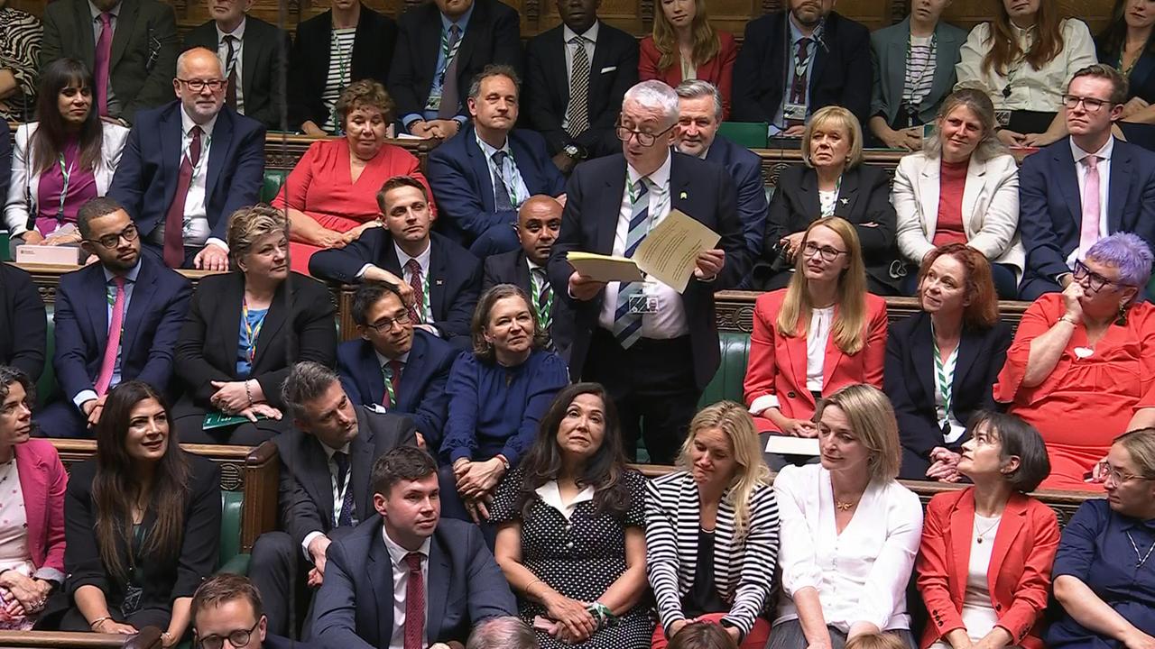 Sir Lindsay Hoyle steht - umringt von sitzenden Abgeordneten. Er hält ein Dokument in Händen, aus dem er vorliest.