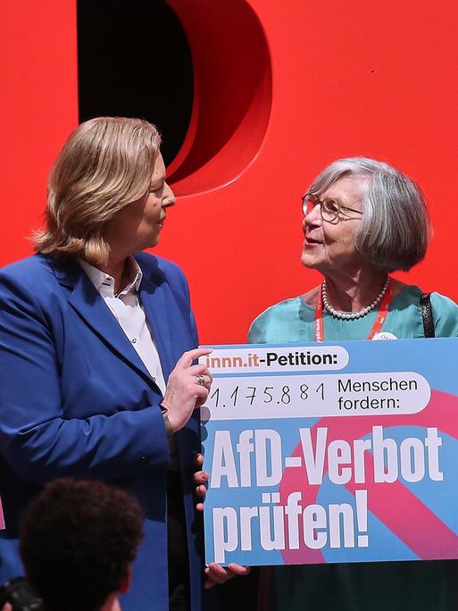 42. SPD-Bundesparteitag: Bundesarbeitsministerin Bärbel Bas und Bundesfinanzminister Lars Klingbeil (SPD) heben mit Betina Kern von 'Omas gegen Rechts' ein Schild zur Prüfung eines AfD-Verbots hoch, auf dem steht: "AfD-Verbot prüfen!"