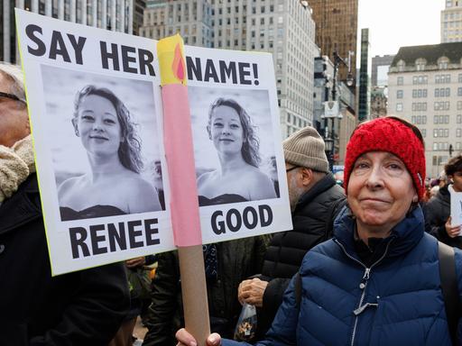 Eine Demonstrantin hält ein Plakat mit zwei Bildern der von einem Beamten der US-Einwanderungsbehörde ICE erschossenen Renee Good in die Höhe. Eine Demonstrantin hält ein Plakat mit zwei Bildern der von einem Beamten der US-Einwanderungsbehörde ICE erschossenen Renee Good in die Höhe.