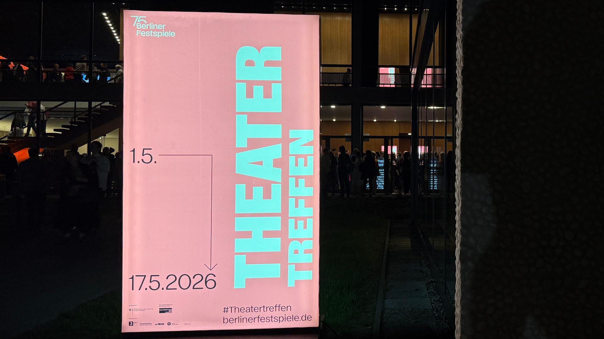 Eine rosafarbene Werbetafel am Haus der Berliner Festspiele. Darauf steht in hellblauer Schrift zweimal das Wort "Theater".