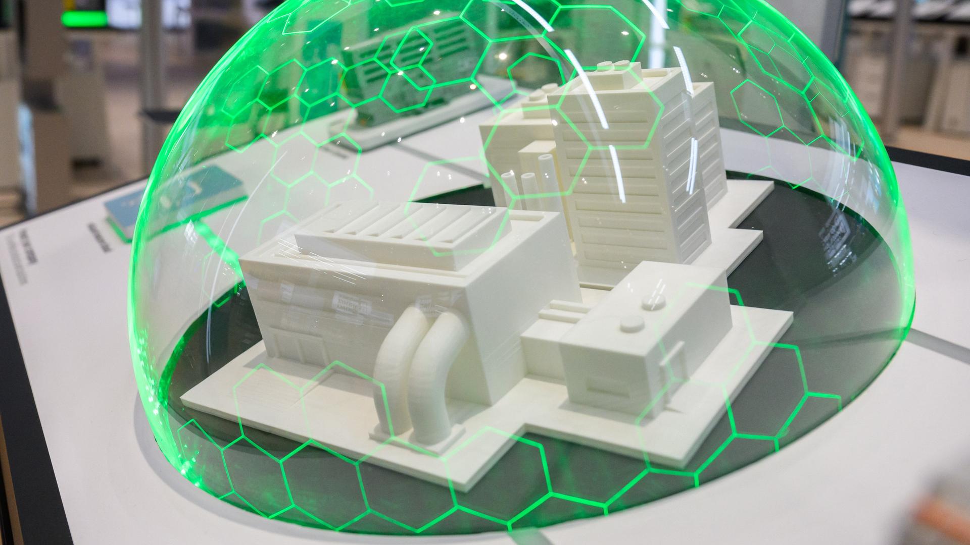 Auf dem Bild siehte man eine Industrieanlage, umgeben voneinem  grün leuchtendem Schutzschild.