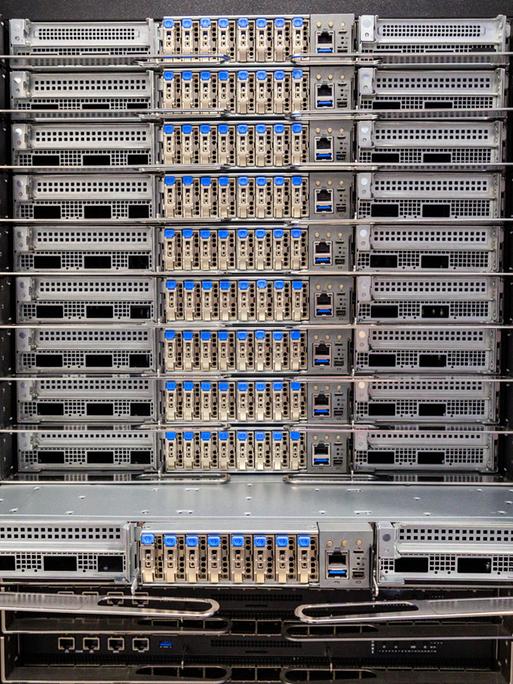 Blick in einen Supercomputer. Verschiedene elektronische Bauteile sind in einem Schrank miteinander verbunden. 
