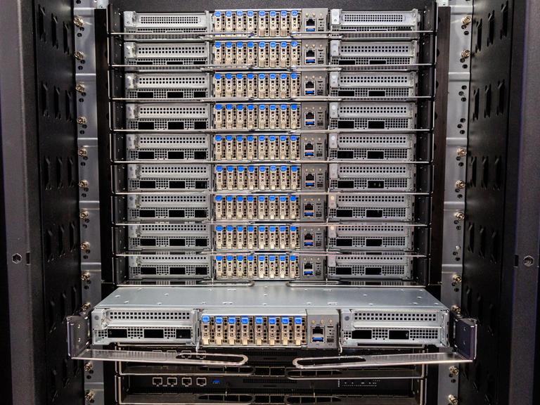 Blick in einen Supercomputer. Verschiedene elektronische Bauteile sind in einem Schrank miteinander verbunden. 