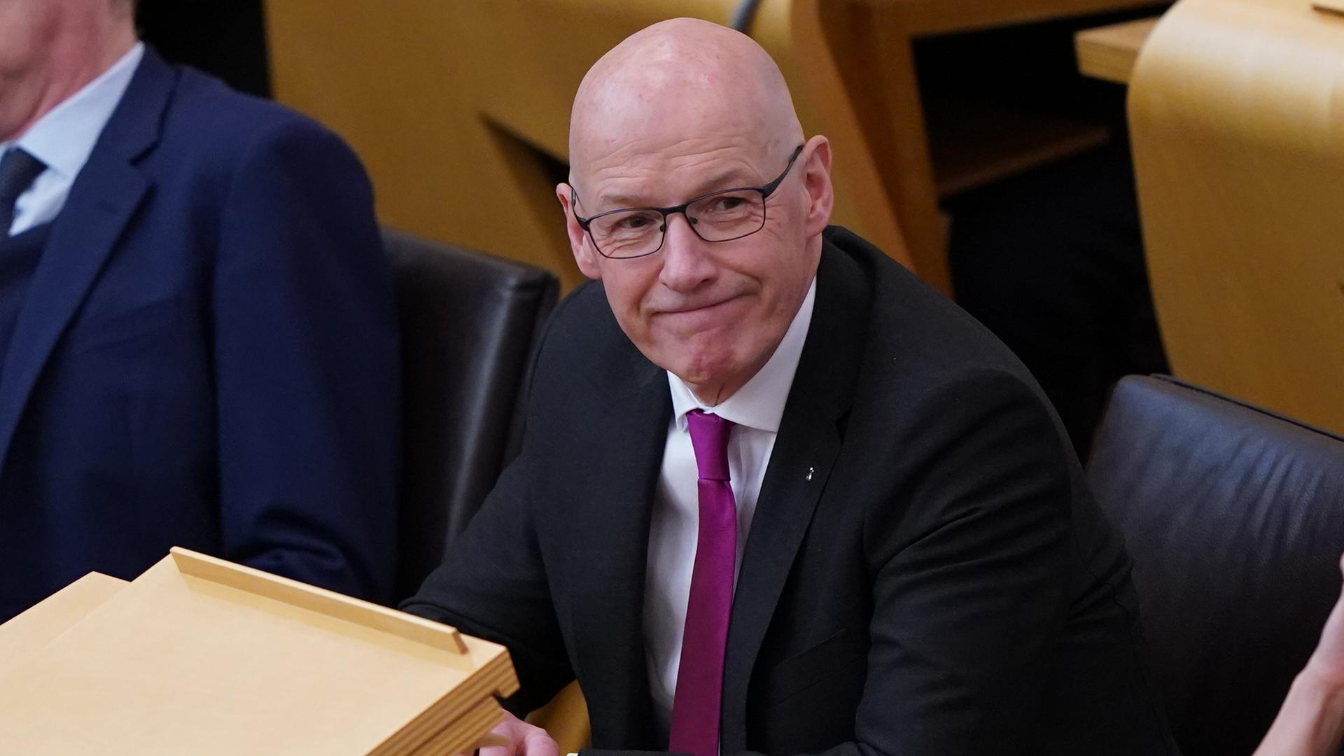 Der schottische Politiker John Swinney sitzt im Plenarsaal des Parlaments. Der schottische Politiker John Swinney sitzt im Plenarsaal des Parlaments.