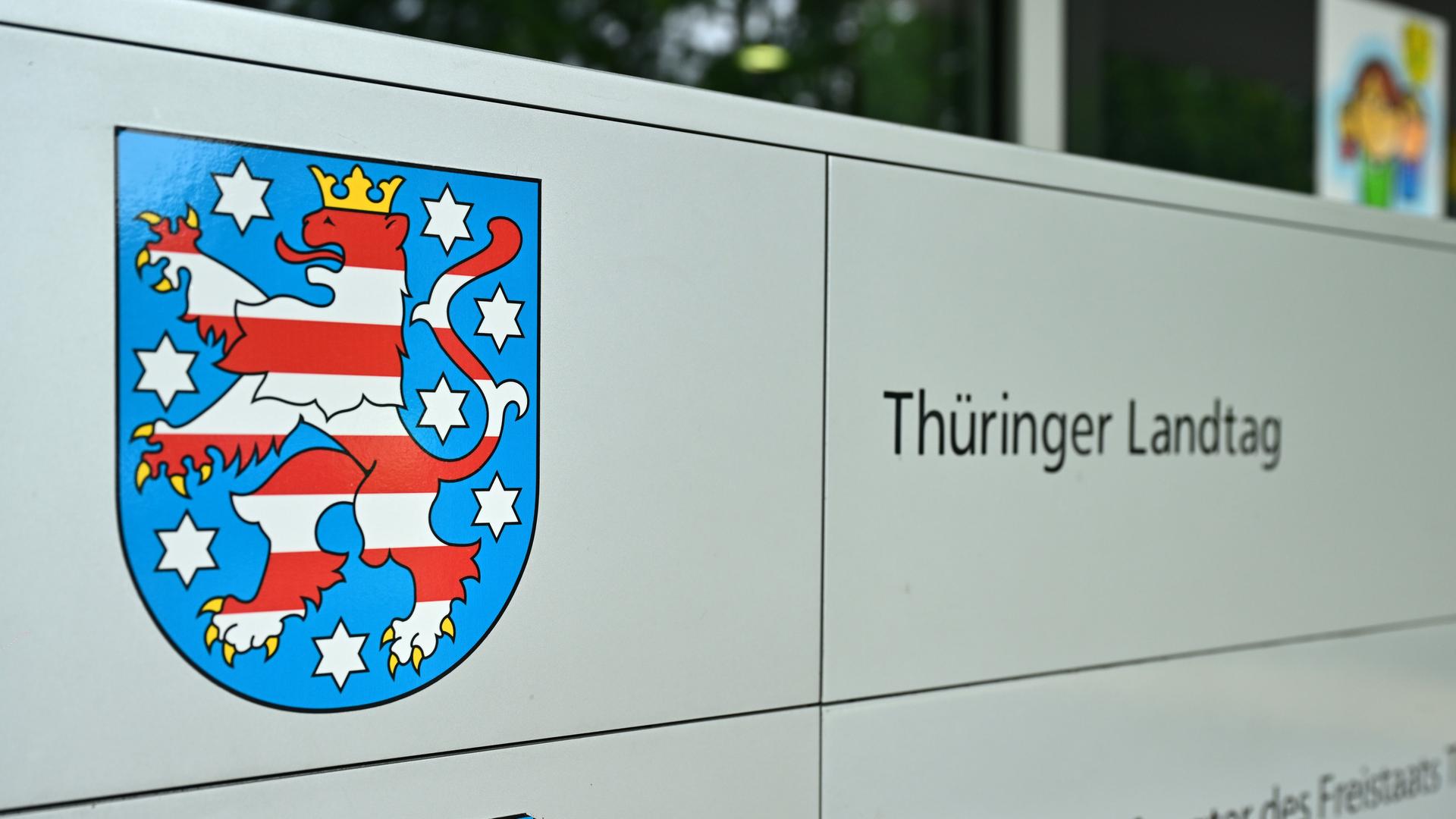 Ein Schild zeigt das Wappen des Landes Thüringen. Daneben steht "Thüringer Landtag".