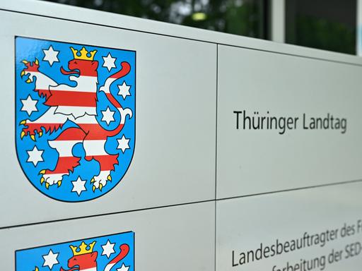 Ein Schild zeigt das Wappen des Landes Thüringen. Daneben steht "Thüringer Landtag".