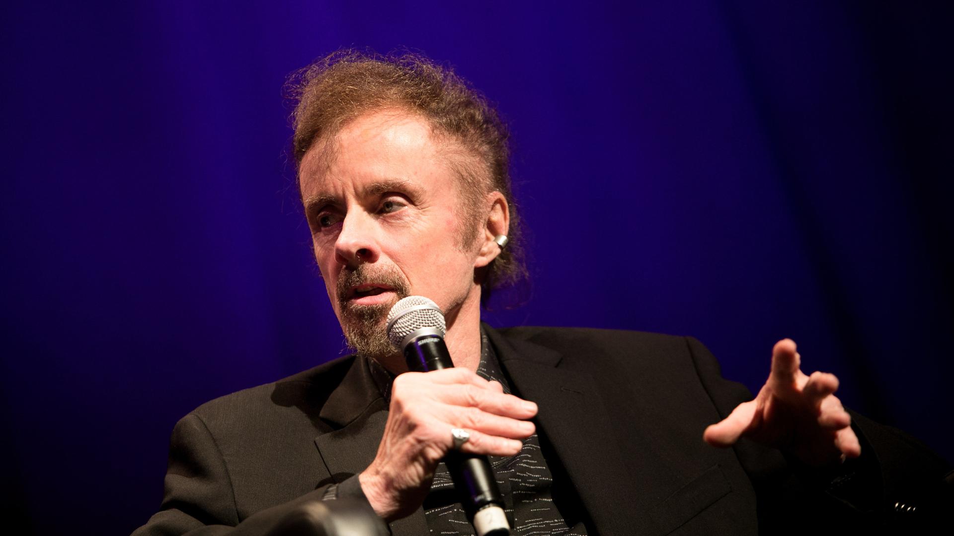 Der amerikanische Schriftsteller T. C. Boyle im Porträt mit Mikrofon Der amerikanische Schriftsteller T. C. Boyle im Porträt mit Mikrofon