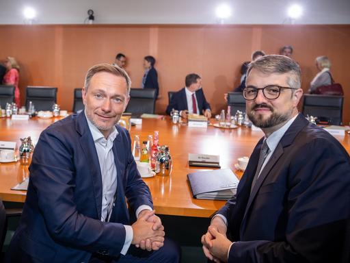 Christian Lindner (FDP, l), Bundesminister der Finanzen, sitzt neben Wolf Heinrich Reuter, Staatssekretär im Finanzministerium für den Haushalt, zu Beginn der Sitzung des Bundeskabinetts im Kanzleramt am Kabinettstisch. 