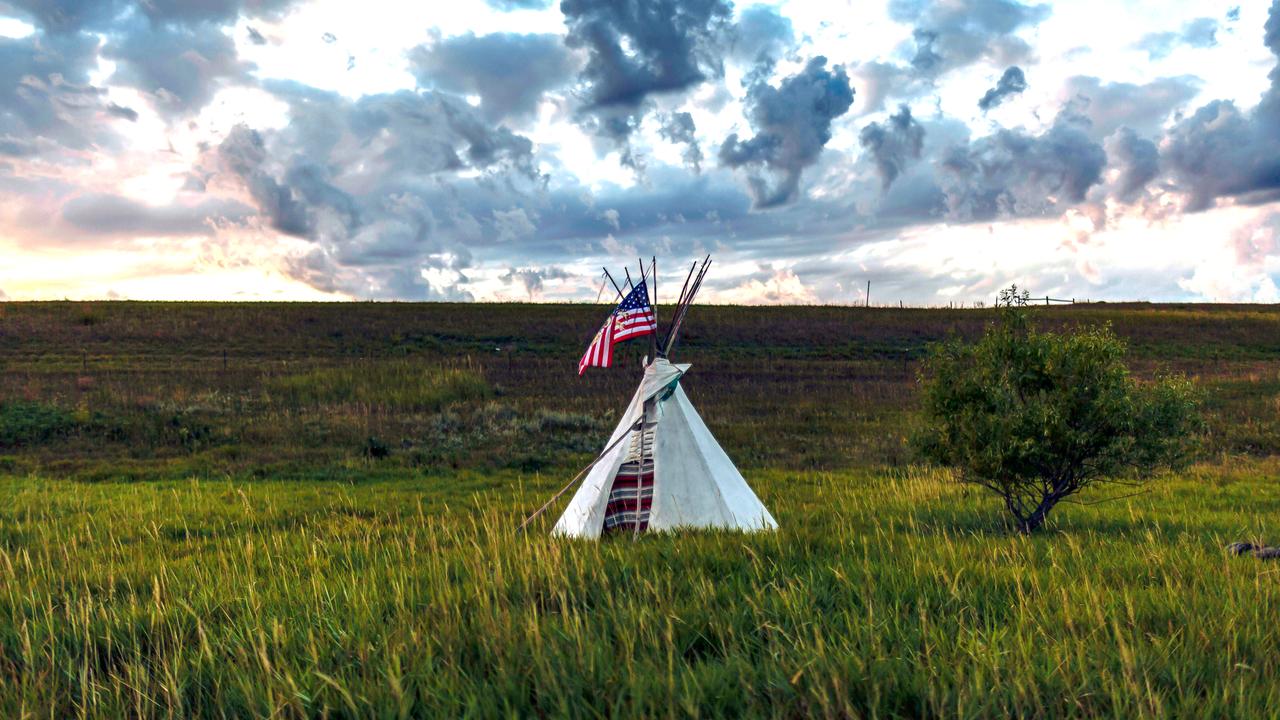 Ein Tipi steht mit einer amerikanische Flagge auf einem Grasfeld in der Nähe des Standing Rock Sioux Reservats in North Dakota.