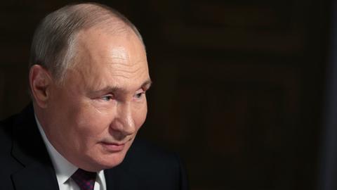Russlands Präsident Putin in einem Interview. Der Hintergrund ist schwarz.