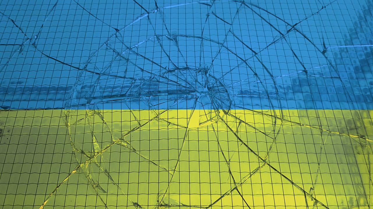 Eine ukrainische Flagge hinter einer zerbrochenen Glasscheibe
