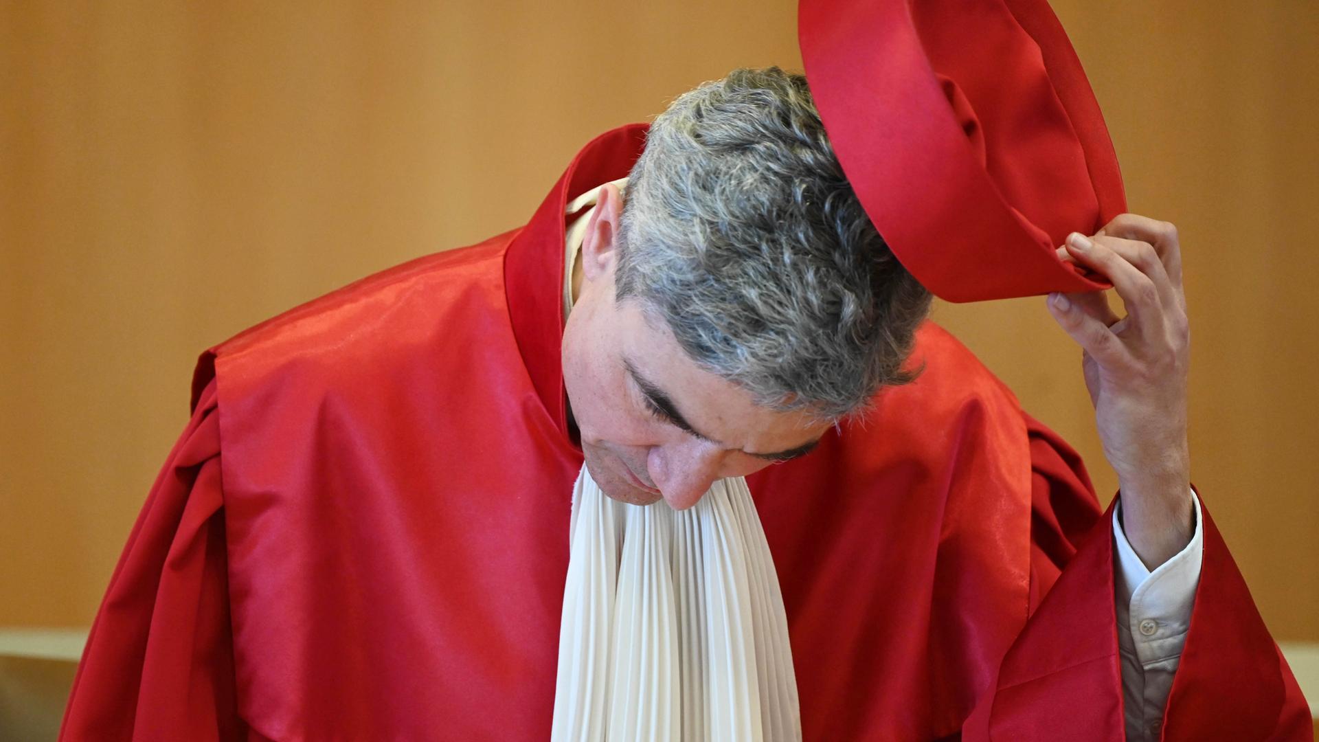Stephan Harbarth nimmt den roten Hut der Bundesverfassungsrichterrobe vom Kopf. Stephan Harbarth nimmt den roten Hut der Bundesverfassungsrichterrobe vom Kopf.