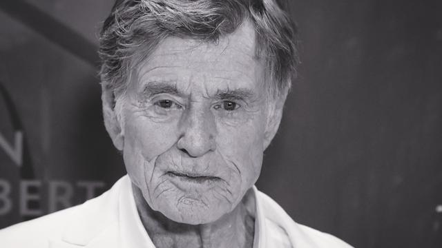 Ein älterer Mann mit weißem Hemd.