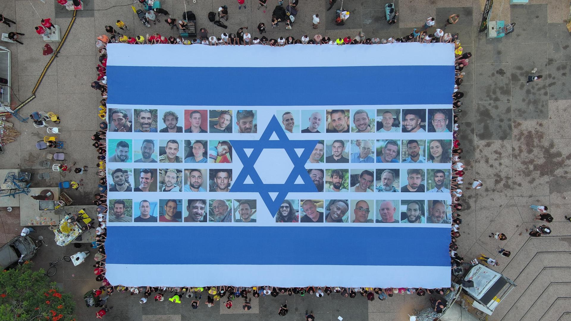 Eine riesige Fahne mit Bildern der nach Gaza verschleppten israelischen Geiseln von oben fotografiert