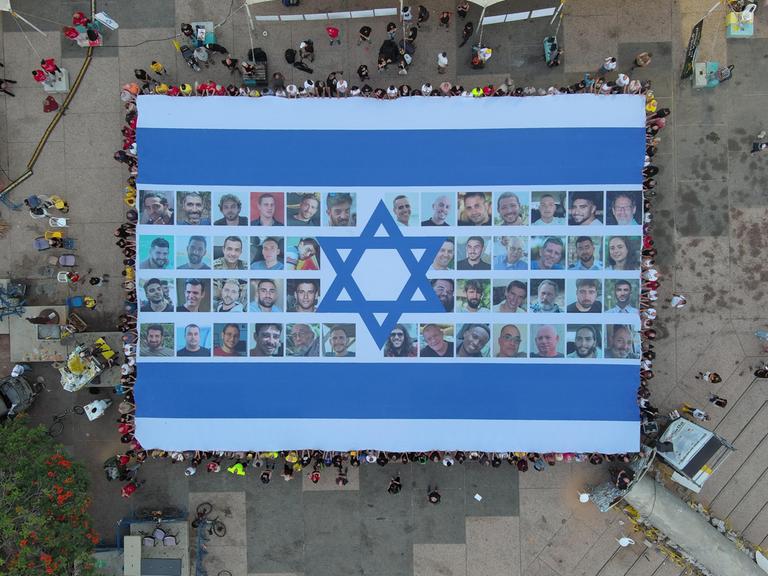 Eine riesige Fahne mit Bildern der nach Gaza verschleppten israelischen Geiseln von oben fotografiert