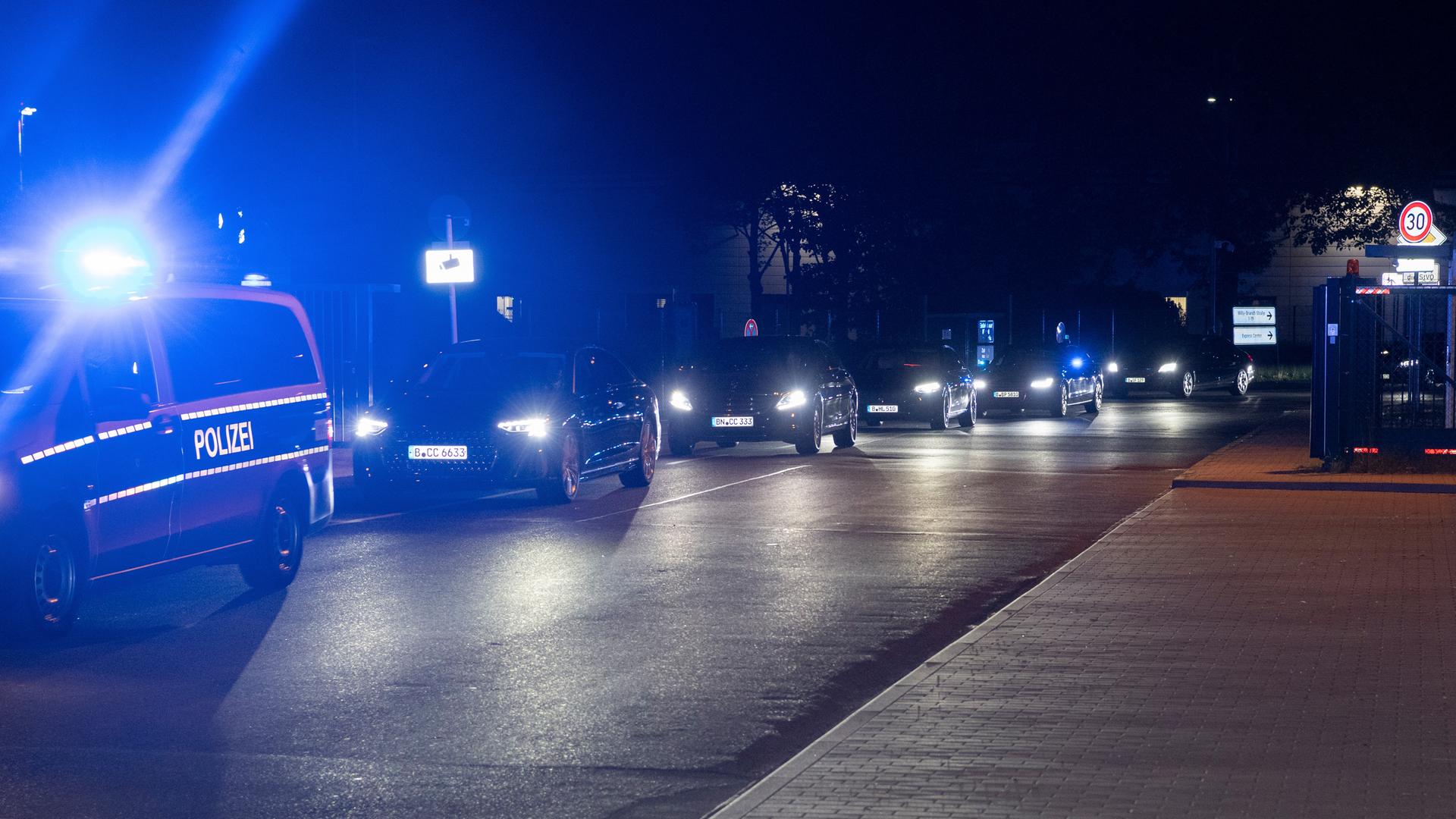 Ein Convoi mit Einsatzfahrzeugen der Polizei, Limousinen und gepanzerten Fahrzeugen verlässt das Gelände des Flughafen Schönefeld.