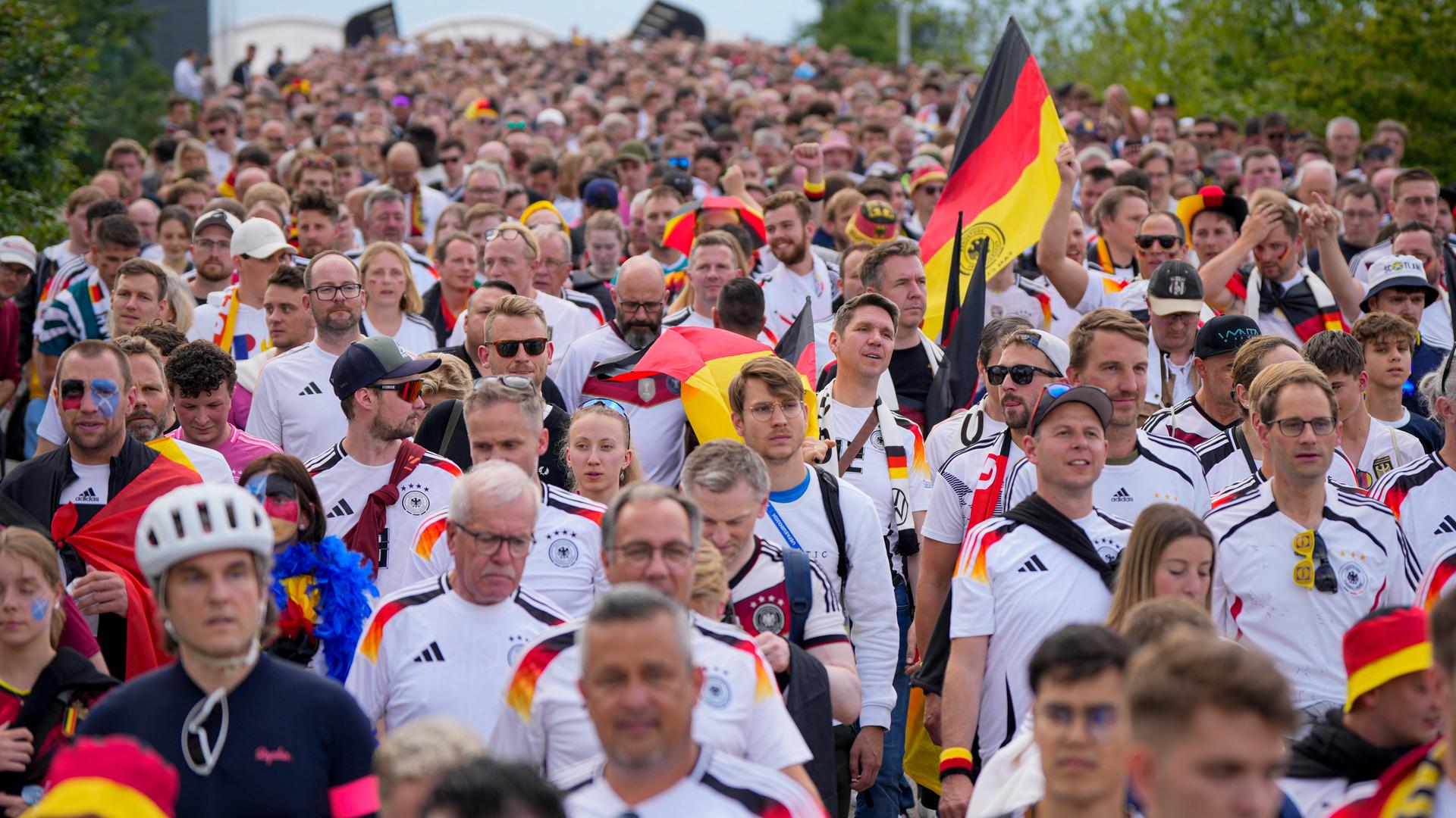 Mit Fahnen und Trikot ziehen deutsche Fußballfans ins Stadion zum ersten Spiel bei der Herren-Europameisterschaft gegen Schottland.