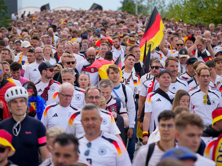 Mit Fahnen und Trikot ziehen deutsche Fußballfans ins Stadion zum ersten Spiel bei der Herren-Europameisterschaft gegen Schottland.