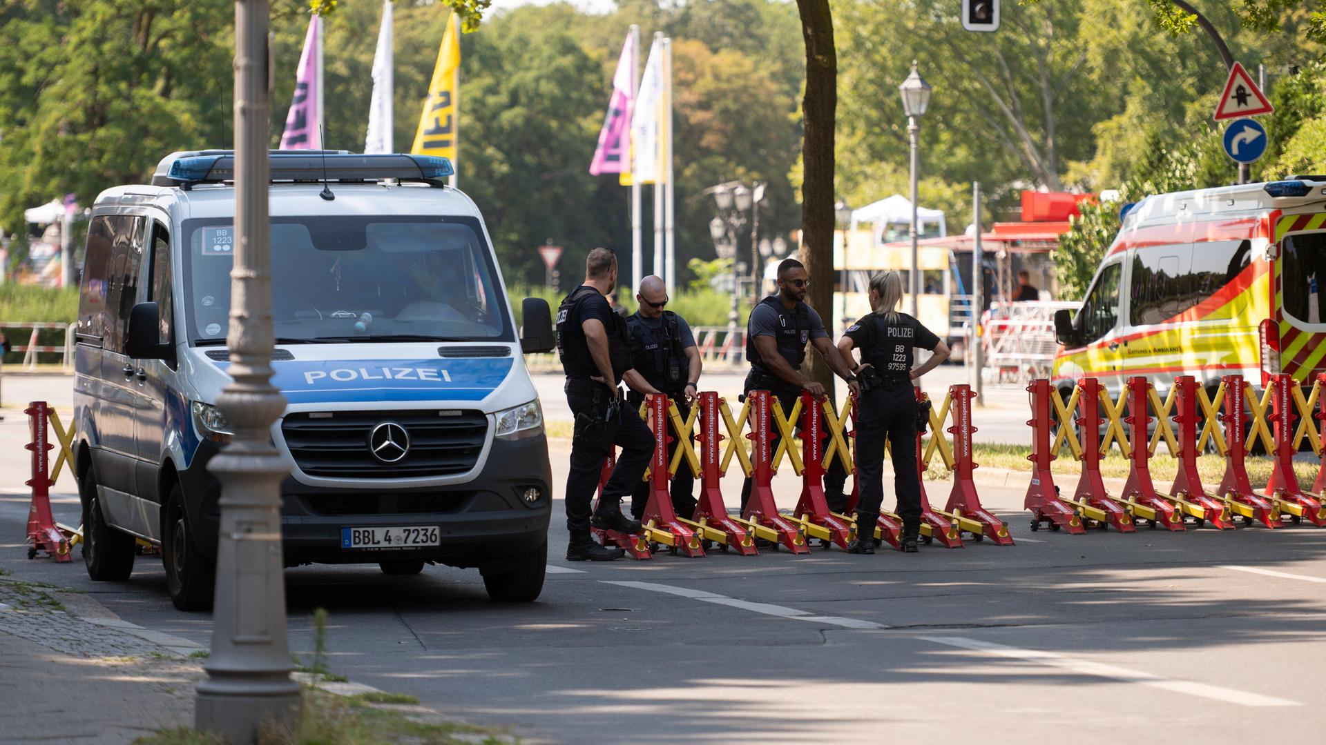 Polizisten stehen am Rande der Demonstration "Rave The Planet Parade 2026" hinter einer Absperrung. 