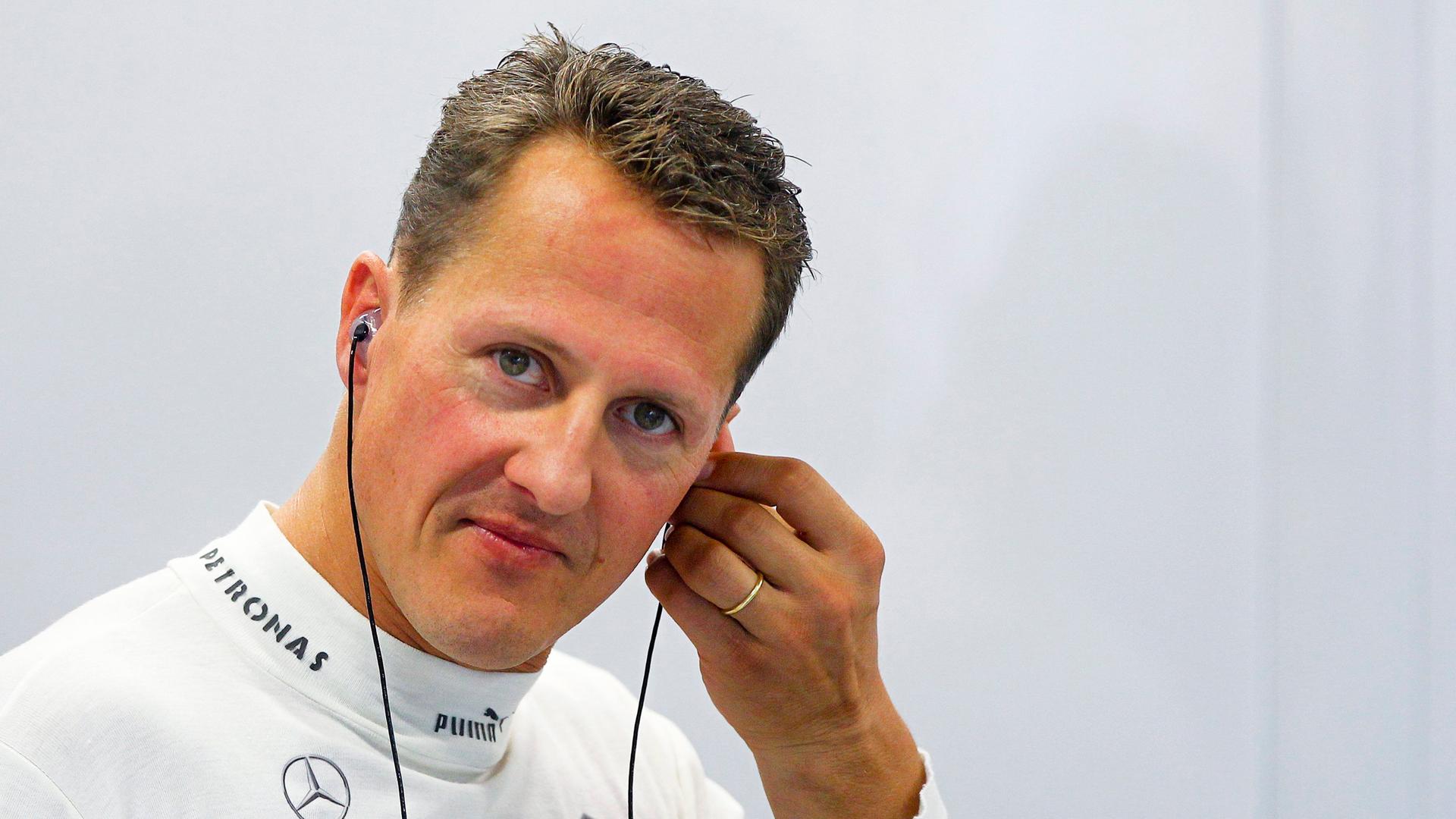 Der ehemalige Formel-1-Fahrer Michael Schumacher steckt sich 2012 einen Kopfhörer ins Ohr.