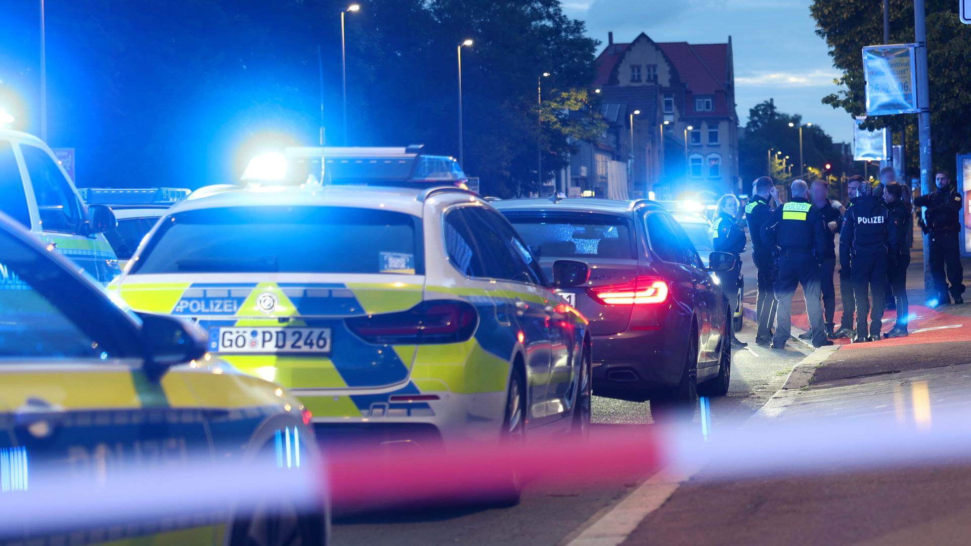 Polizisten und Polizeifahrzeuge stehen hinter einer Absperrung. Ein Polizist ist bei einer Auseinandersetzung zwischen zwei Personengruppen im niedersächsischen Göttingen angeschossen worden. Polizisten und Polizeifahrzeuge stehen hinter einer Absperrung. Ein Polizist ist bei einer Auseinandersetzung zwischen zwei Personengruppen im niedersächsischen Göttingen angeschossen worden.