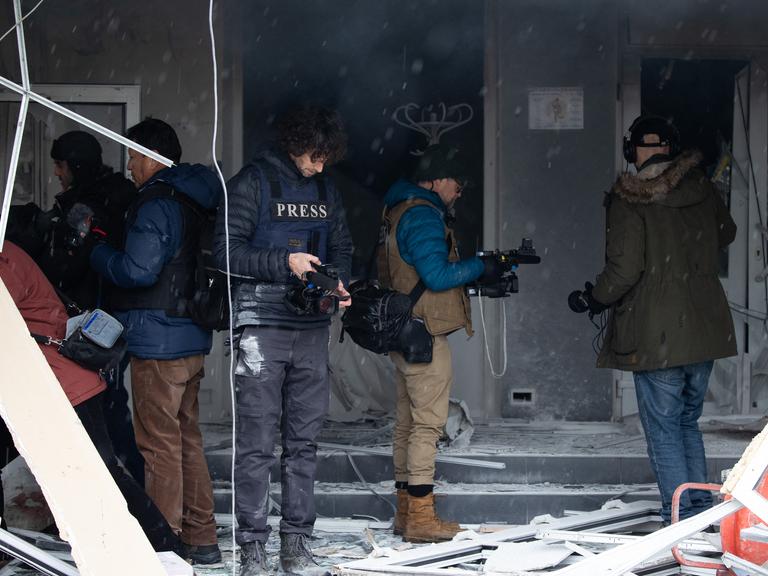 Kriegsreporter und Fotografen in Kiew tragen Helme und weitere Schutzausrüstung.