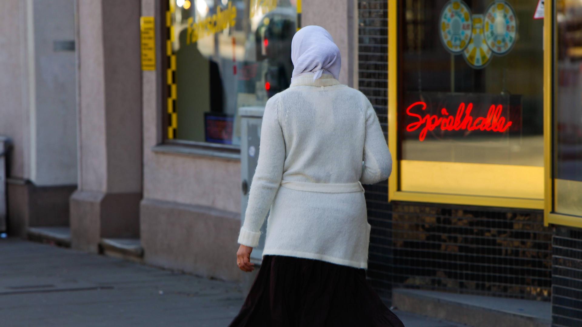 Eine Frau mit Kopftuch zu Fuß unterwegs in Hamburg.