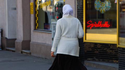 Eine Frau mit Kopftuch zu Fuß unterwegs in Hamburg.