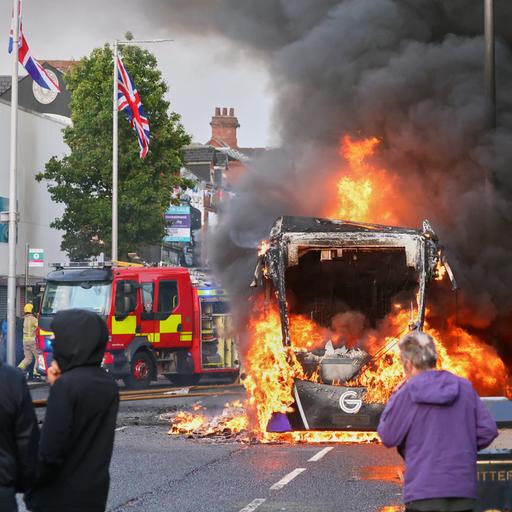 In Belfast kommt es während einer Demonstration zu Ausschreitungen. Fahrzeuge stehen in Flammen. 