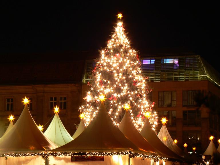 Beleuchteter Weihnachtsbaum auf dem Weihnachtsmarkt am Kölner Dom. 