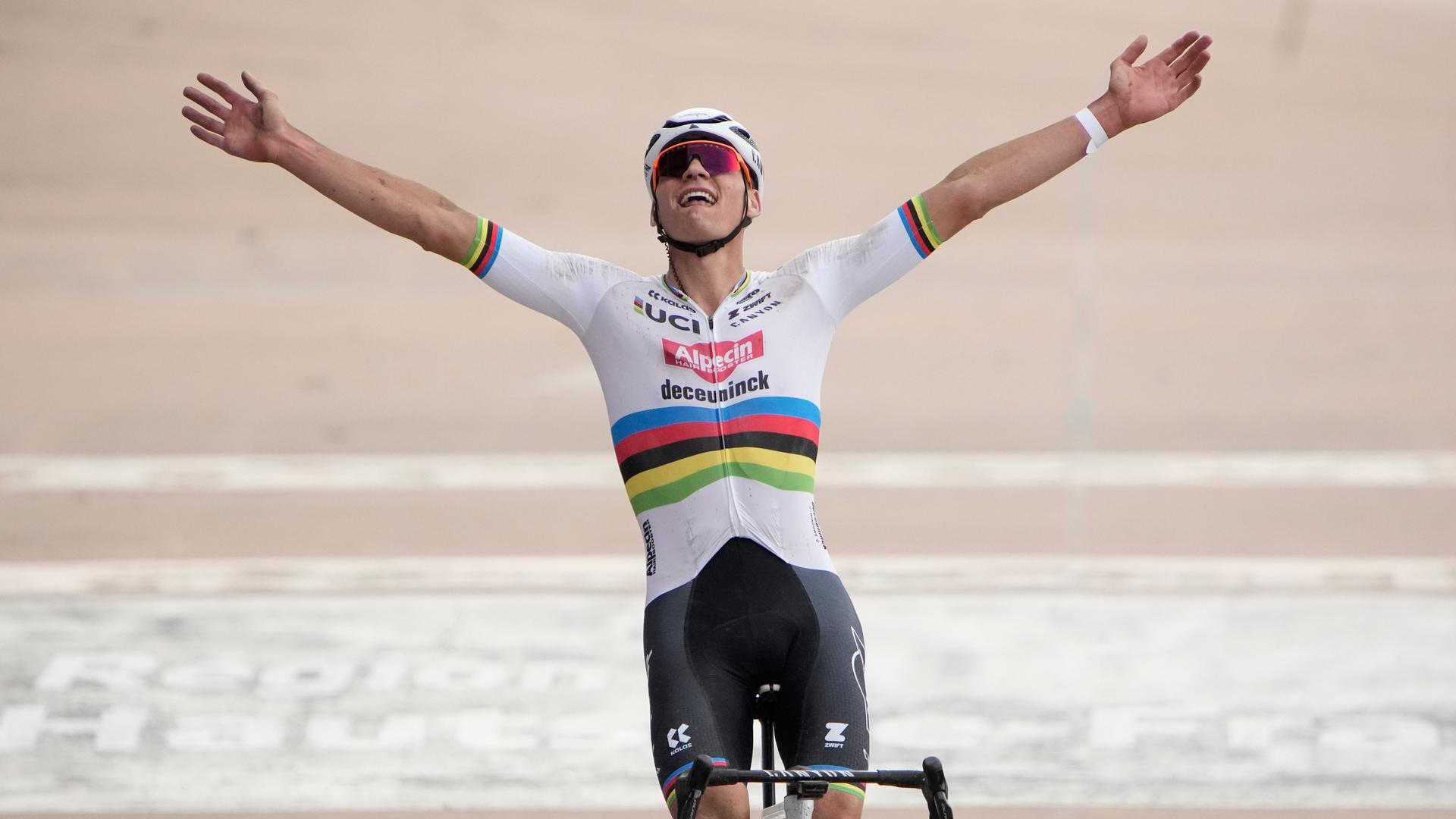 Mathieu van der Poel reckt auf seinem Rennrad die Arme in die Höhe. Mathieu van der Poel reckt auf seinem Rennrad die Arme in die Höhe.