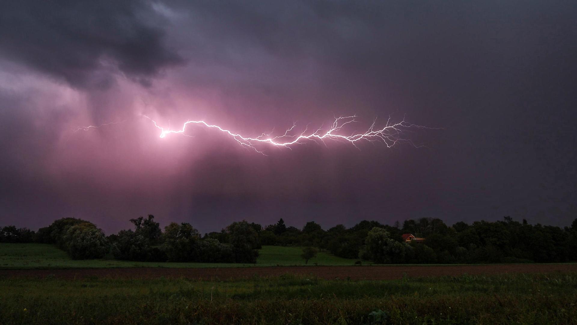 Blitze eines Gewitters sind am Abendhimmel zu sehen. 