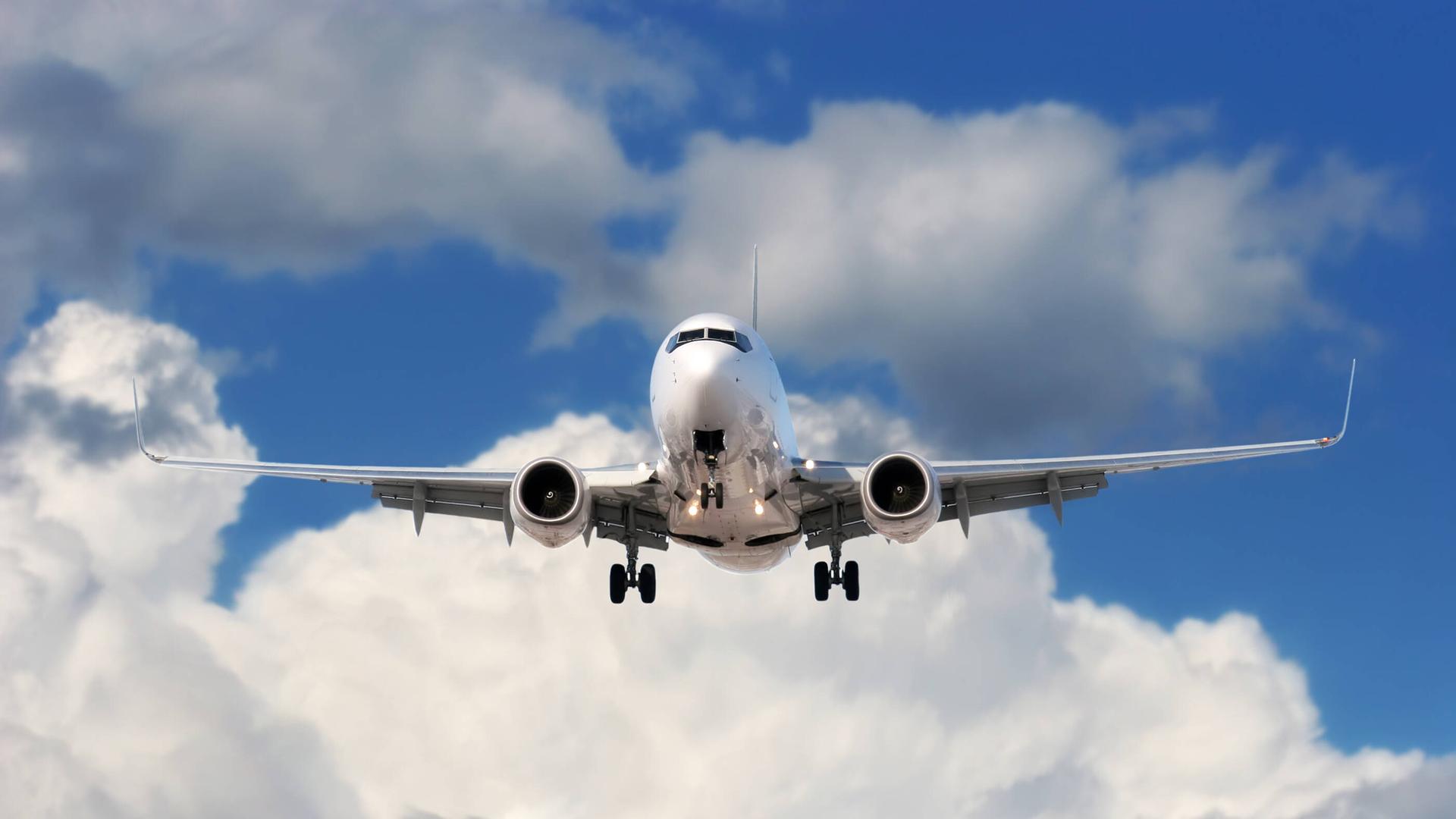 Ein Flugzeug fliegt bei blauem Himmel mit Wolken. Ein Flugzeug fliegt bei blauem Himmel mit Wolken.