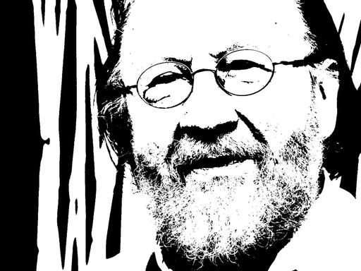 Georg Katzer schaut auf einem schwarz-weiß-Foto freundlich in die Kamera mit Brille und Bart.
