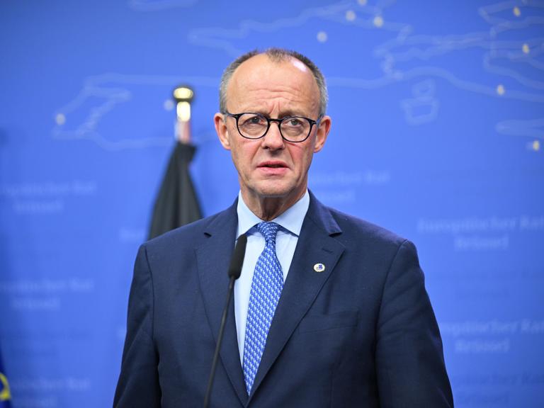 Bundeskanzler Friedrich Merz steht in Anzug und Krawatte vor einem blauen Hintergrund. Bundeskanzler Friedrich Merz steht in Anzug und Krawatte vor einem blauen Hintergrund.