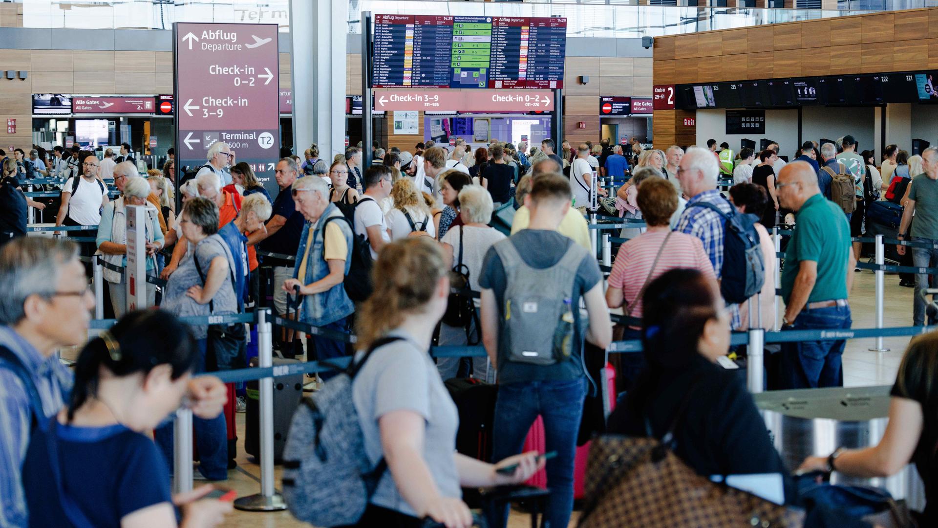 Passagiere warten in einem Terminal am Berliner Flughafen BER. 
