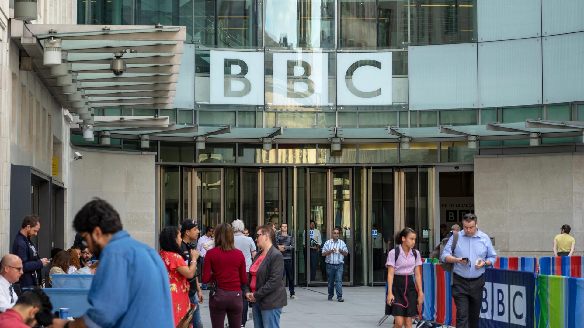 Menschen stehen und gehen vor dem Eingang des Broadcasting House in London, dem Hauptsitz der British Broadcasting Corporation (BBC). Foto vom 09. Mai 2018.