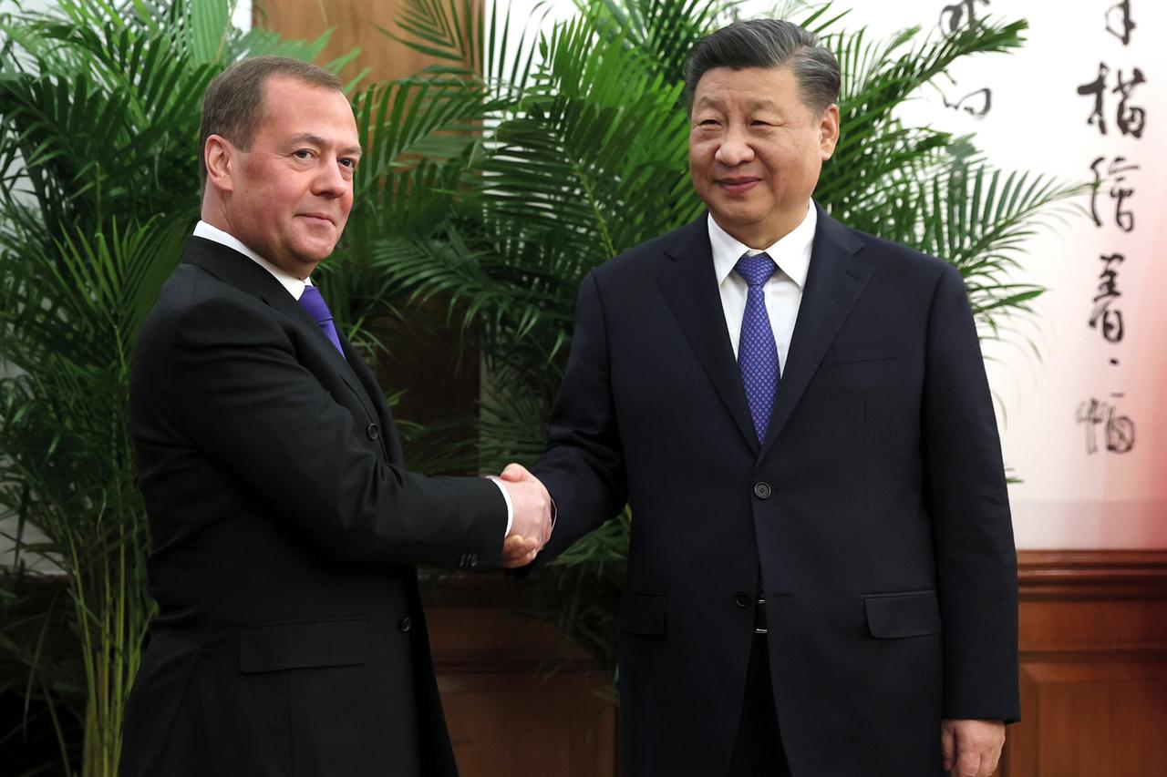 Peking: Dmitri Medwedew, stellvertretender Vorsitzender des russischen Sicherheitsrates und Vorsitzender der Partei Einiges Russland", und Xi Jinping, Präsident von China, reichen sich während ihres Treffens die Hände. 