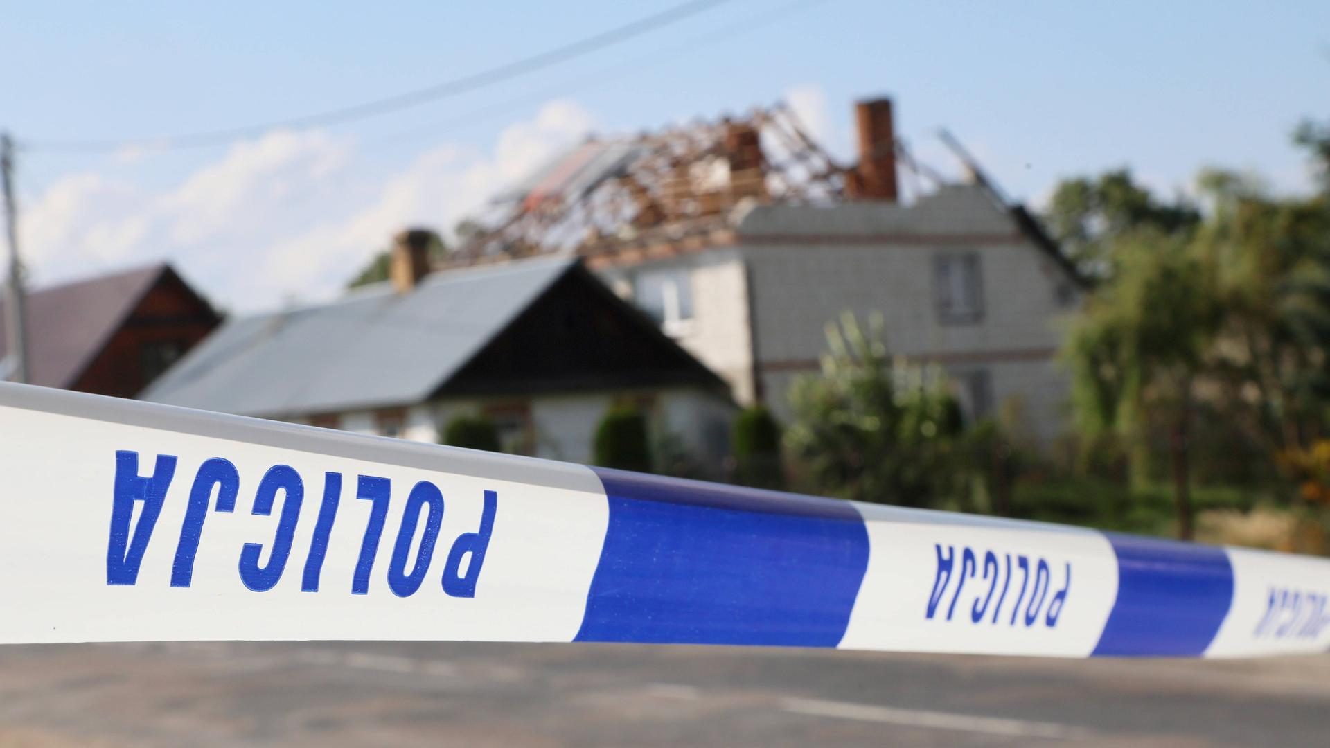 Hinter dem Absperrband der Polizei sieht man ein beschädigtes Haus in einem polnischen Dorf. Hinter dem Absperrband der Polizei sieht man ein beschädigtes Haus in einem polnischen Dorf.