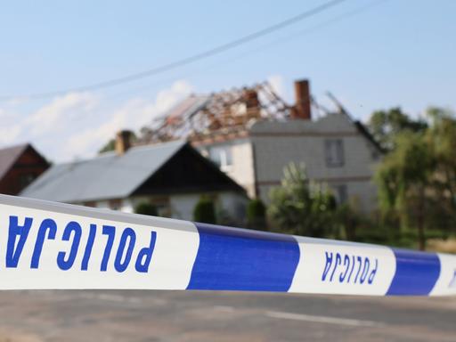 Hinter dem Absperrband der Polizei sieht man ein beschädigtes Haus in einem polnischen Dorf.