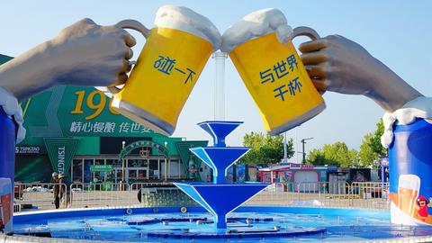 Eine große Skulptur zeigt zwei Biergläser, mit denen angestoßen wird. Das überlaufende Bier bildet in der Mitte einen Springbrunnen.