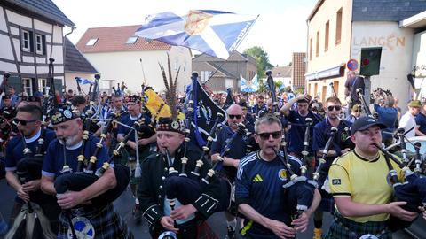 Männer in Kilts und Dudelsäcken laufen durch eine Strasse. Die „Tartan Army“ nimmt vor einem Fußballspiel im Kölner Stadion an einem organisierten Marsch zum Stadion teil. 