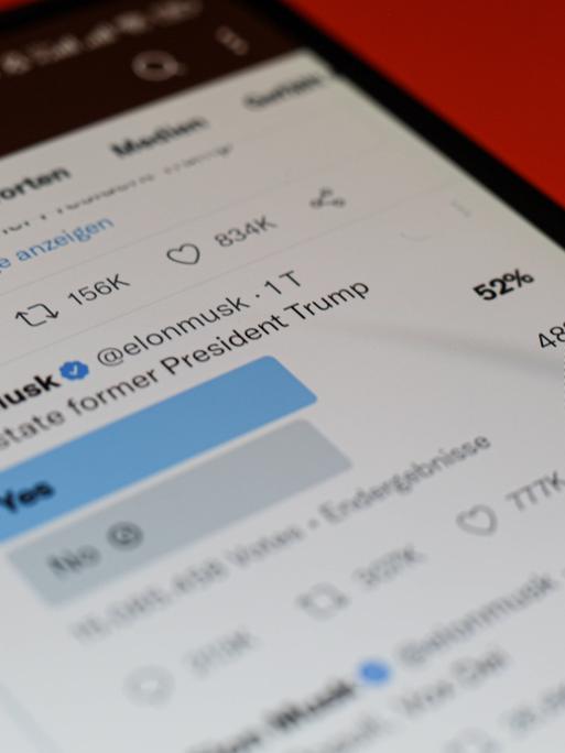 Auf einem Smartphonebildschirm ist am 20.11.2022 ein Tweet von Ekon Musk zu sehen, der das Ergebnis seiner Twitter-Umfrage zeigt, ob das Profil des ehemaligen US-Präsident wieder freigeschaltet werden soll. 52 Prozent der Umfragen-Teilnehmerinnen stimmten für ja.