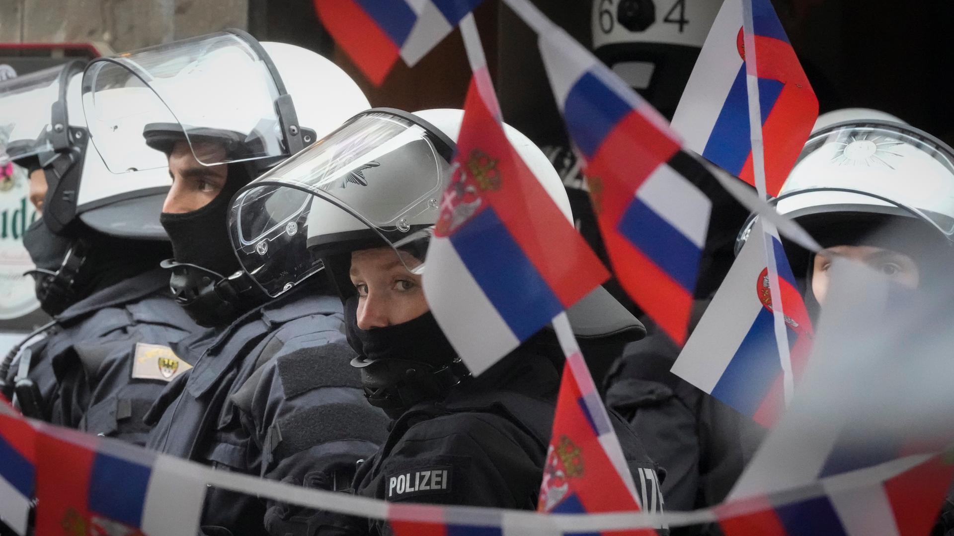 Polizisten stehen neben einem mit serbischen Flaggen geschmückten Restaurant bei der Fußball-Europameisterschaft 2024 in Gelsenkirchen.