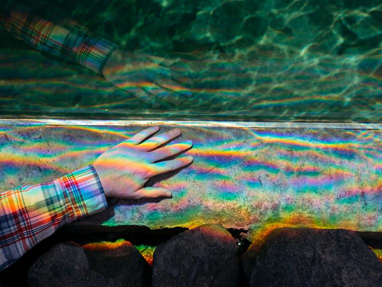 Auf einer Hand bricht sich Licht in allen Regenbogenfarben.