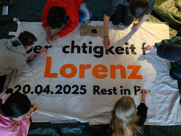 Mehrere Personen beschriften ein Transparent mit dem Schriftzug „Gerechtigkeit für Lorenz“. 